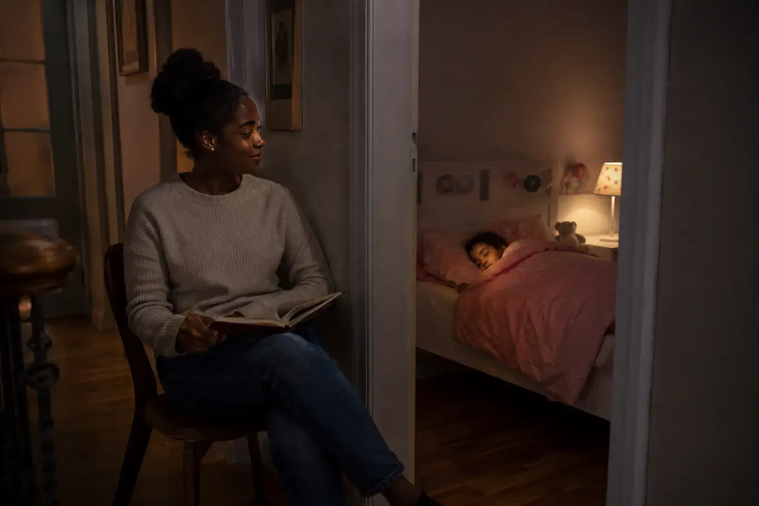 An overnight sitter stays attentive near a sleeping child
